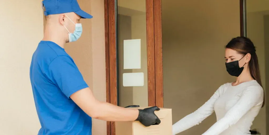 Courier delivering a parcel to a customer at her front door