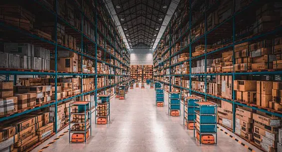 Long warehouse aisle lined with shelves of boxed inventory
