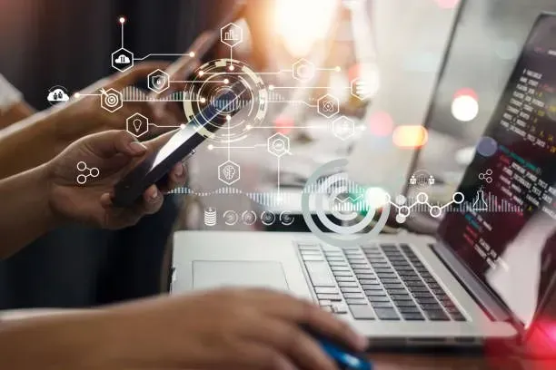 Person using a phone and laptop with digital business icons overlaid