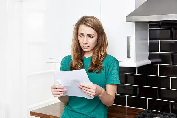 Person reading paperwork at a kitchen counter